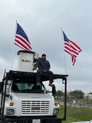 Ed, owner of Ed's Tree Specialists, sitting on his bucket truck in Jacksonville, NC